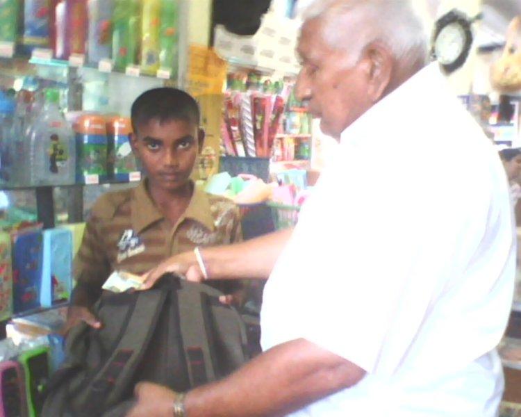 215-gayan-receiving-the-school-bag-with-money-from-mr-gamage